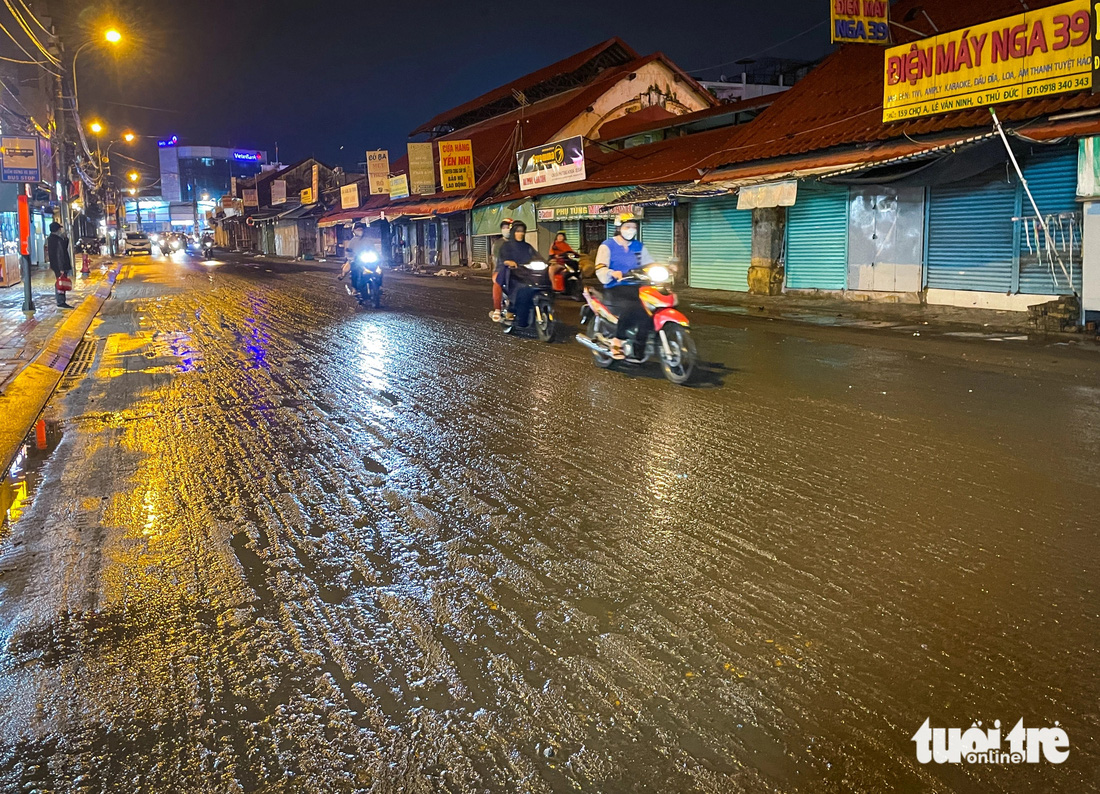 Khoảng 21h, sau khi nước rút, mặt đường khu vực chợ Thủ Đức còn lại toàn bùn - Ảnh: CHÂU TUẤN