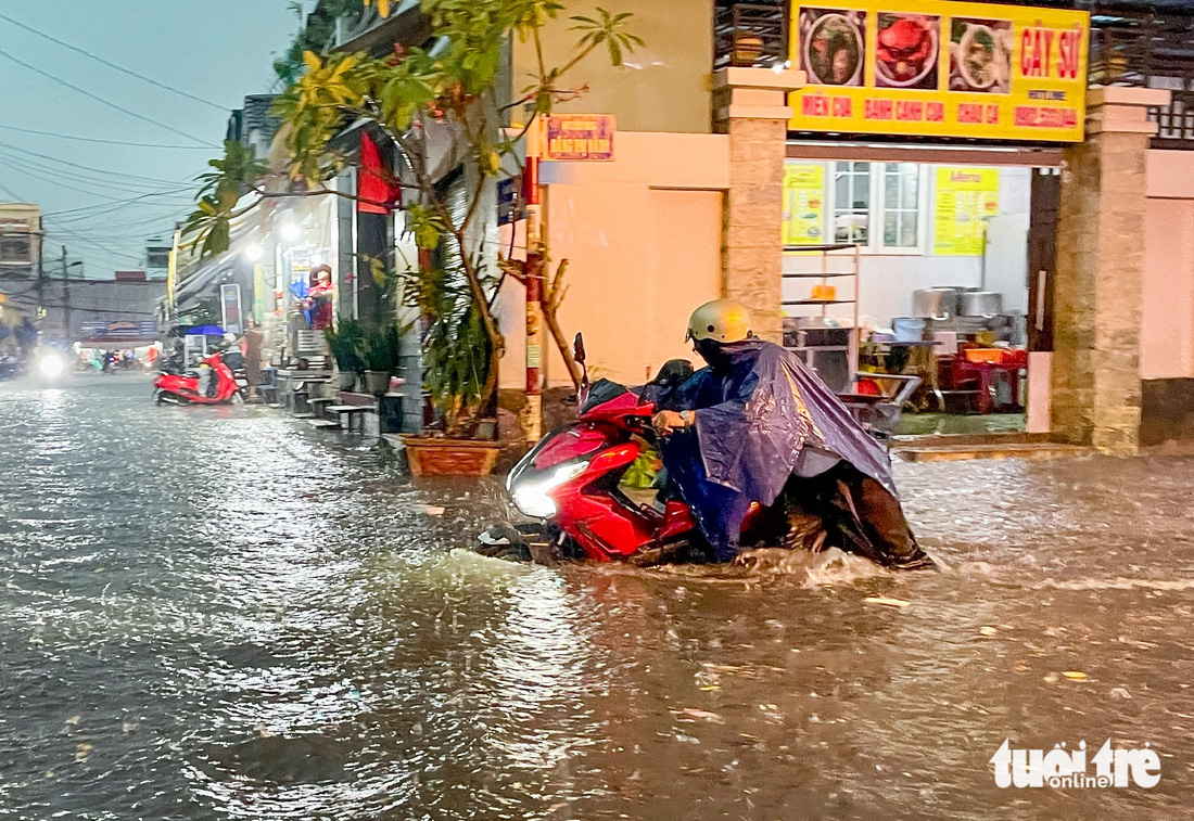 Chiều 15-5, mưa gây ngập diện rộng trên đường Đặng Thị Rành, có đoạn ngập lút bánh, tới yên xe máy - Ảnh: CHÂU TUẤN