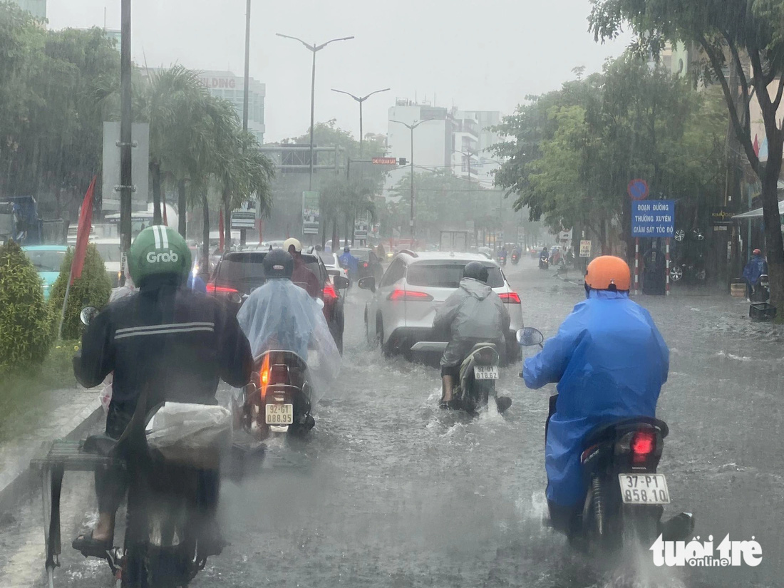 Xe cộ trên đường 2-9 (quận Hải Châu) phải đi vào làn đường gần dải phân cách để tránh ngập sâu - Ảnh: TẤN VŨ