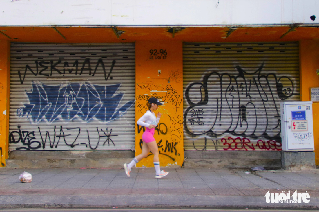 Cánh cửa kéo bằng tôn của các nhà dọc tuyến đường Lê Lợi (quận 1, TP.HCM) phủ kín hình vẽ theo kiểu graffiti (tranh vẽ loại hình nghệ thuật đường phố) lớn nhỏ - Ảnh: TIẾN QUỐC