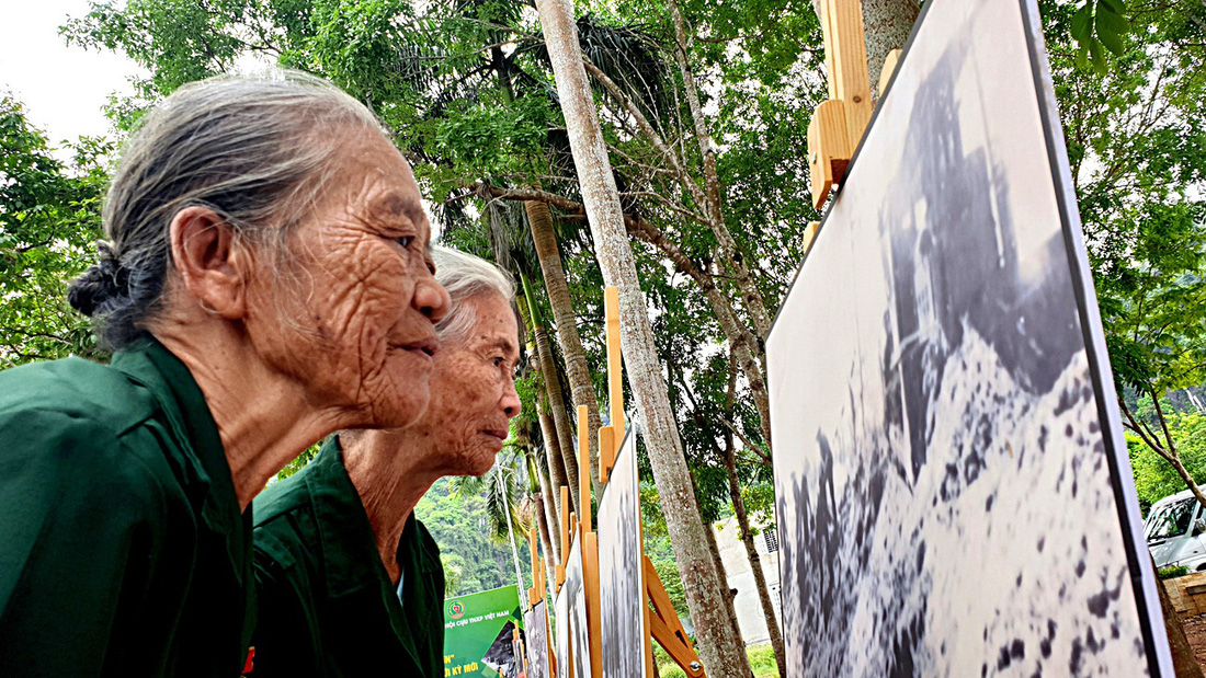 Bà Hoàng Thị Tinh (phía trước) và bà Phạm Thị Khuyển (cùng trú thị trấn Phong Nha, Bố Trạch, Quảng Bình) - hai nữ TNXP năm xưa vẫn tự hào qua hình ảnh tư liệu phá đá mở đường Trường Sơn huyền thoại