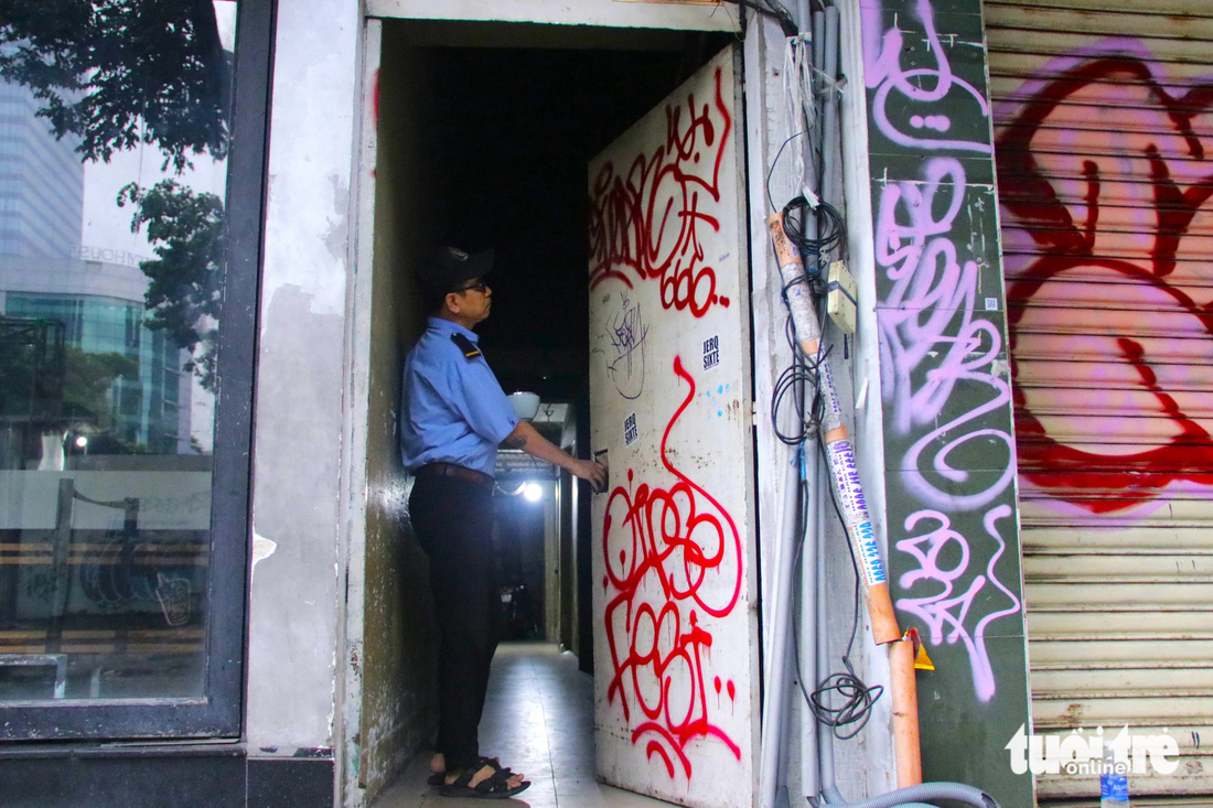 Cánh cửa tôn một cửa hàng tại đường Huỳnh Thúc Kháng (quận 1, TP.HCM) bị xịt sơn đỏ nguệch ngoạc - Ảnh: TIẾN QUỐC