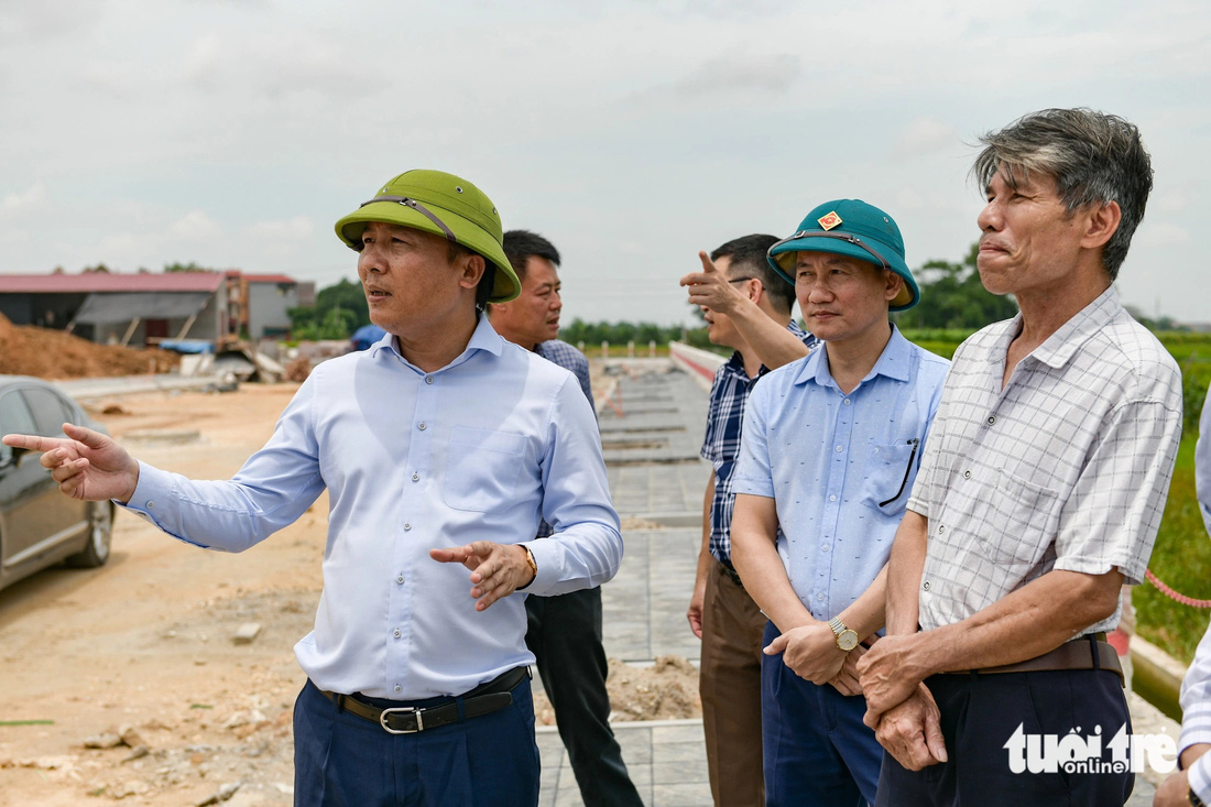 Bí thư Huyện ủy Mê Linh Nguyễn Thanh Liêm (bìa trái) đi kiểm tra tiến độ triển khai dự án đường vành đai 4 trên địa bàn huyện - Ảnh: NAM TRẦN