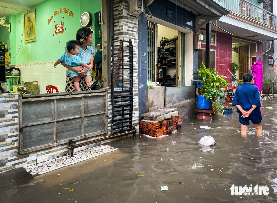 Người dân dùng tấm tôn để chắn nước vào nhà - Ảnh: CHÂU TUẤN