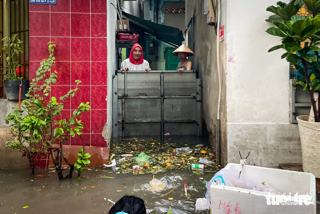 Một lối vào nhà dân bị nước và rác bao vây - Ảnh: CHÂU TUẤN