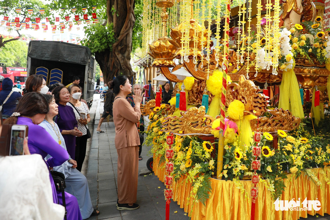 Người dân kính lễ trước xe rước Phật đặt trước cổng chùa Quán Sứ sáng 22-5 - Ảnh: DANH KHANG