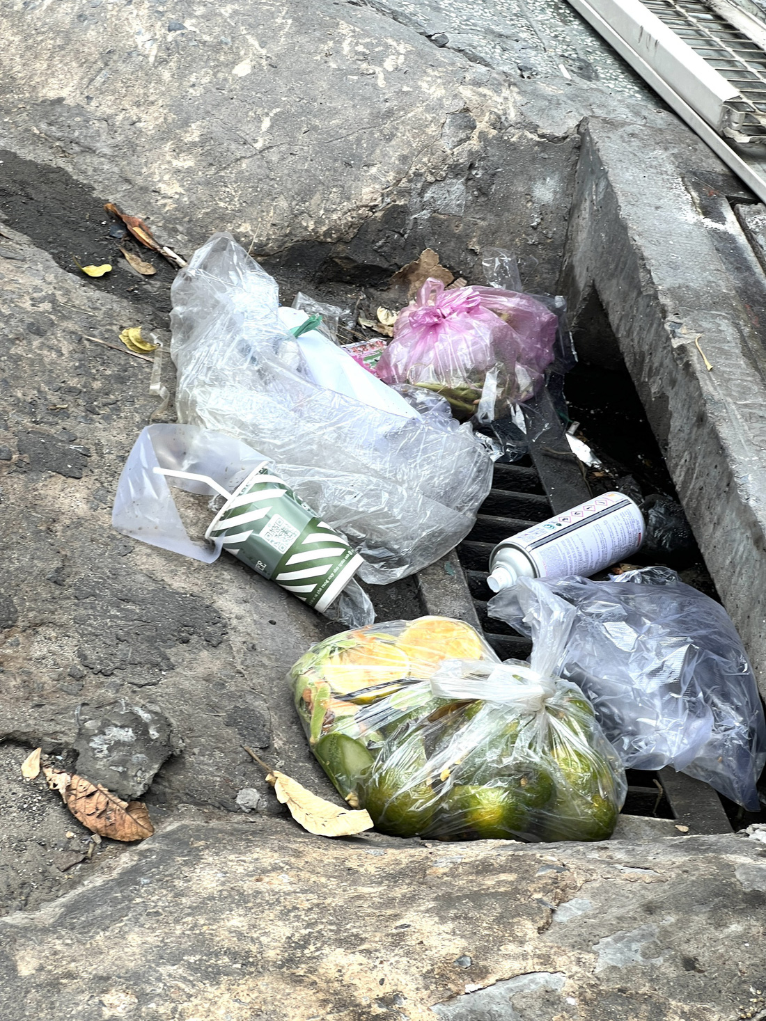 Tất cả rác đều được dồn xuống miệng cống trên đường Phan Văn Trị, quận Gò Vấp - Ảnh: XUÂN ĐOÀN