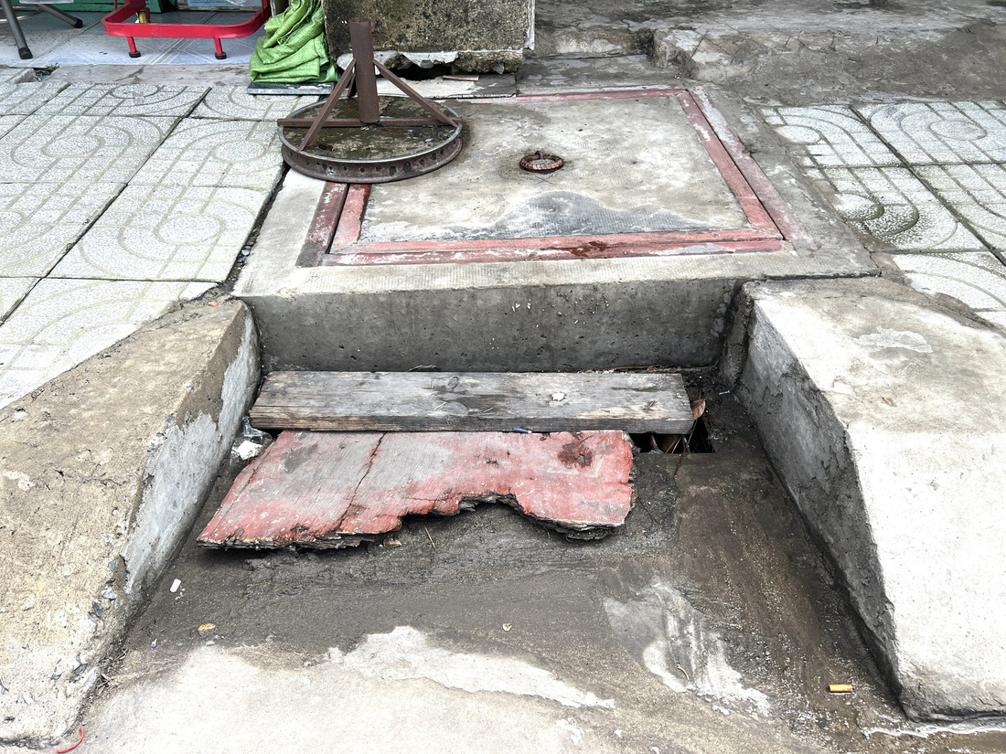 Một miệng cống trên đường 30, phường Linh Đông, TP Thủ Đức bị người dân dùng gỗ ván che kín - Ảnh: XUÂN ĐOÀN