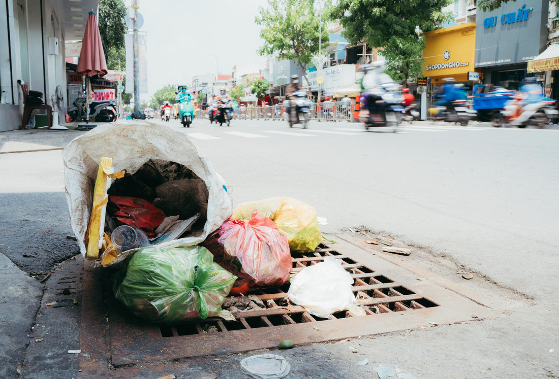 Nắp cống trên đường Quang Trung, phường 11, quận Gò Vấp đầy rác sinh hoạt - Ảnh: THANH HIỆP