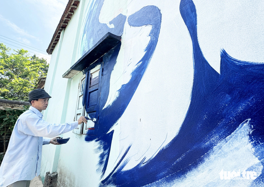 Họa sĩ Vũ Hải thực hiện bức tranh trên tường nhà dân - Ảnh: LÊ TRUNG