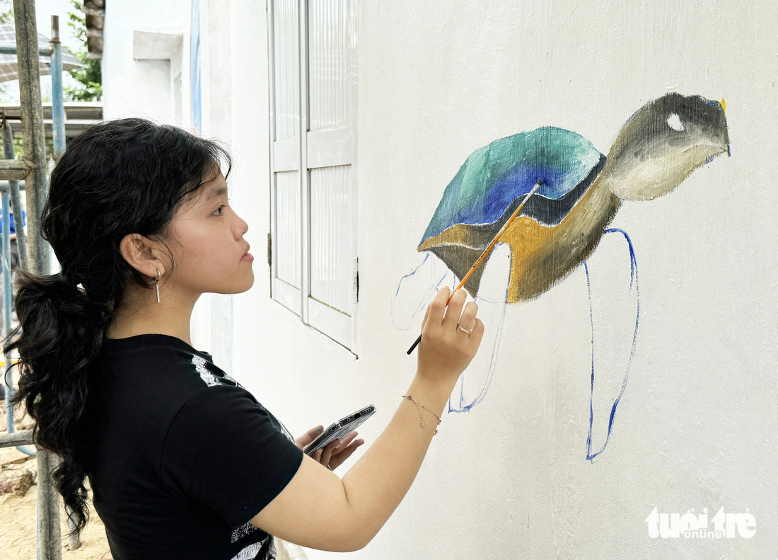 Ngoài họa sĩ có thêm học sinh tham gia vẽ trên tường nhà dân - Ảnh: LÊ TRUNG