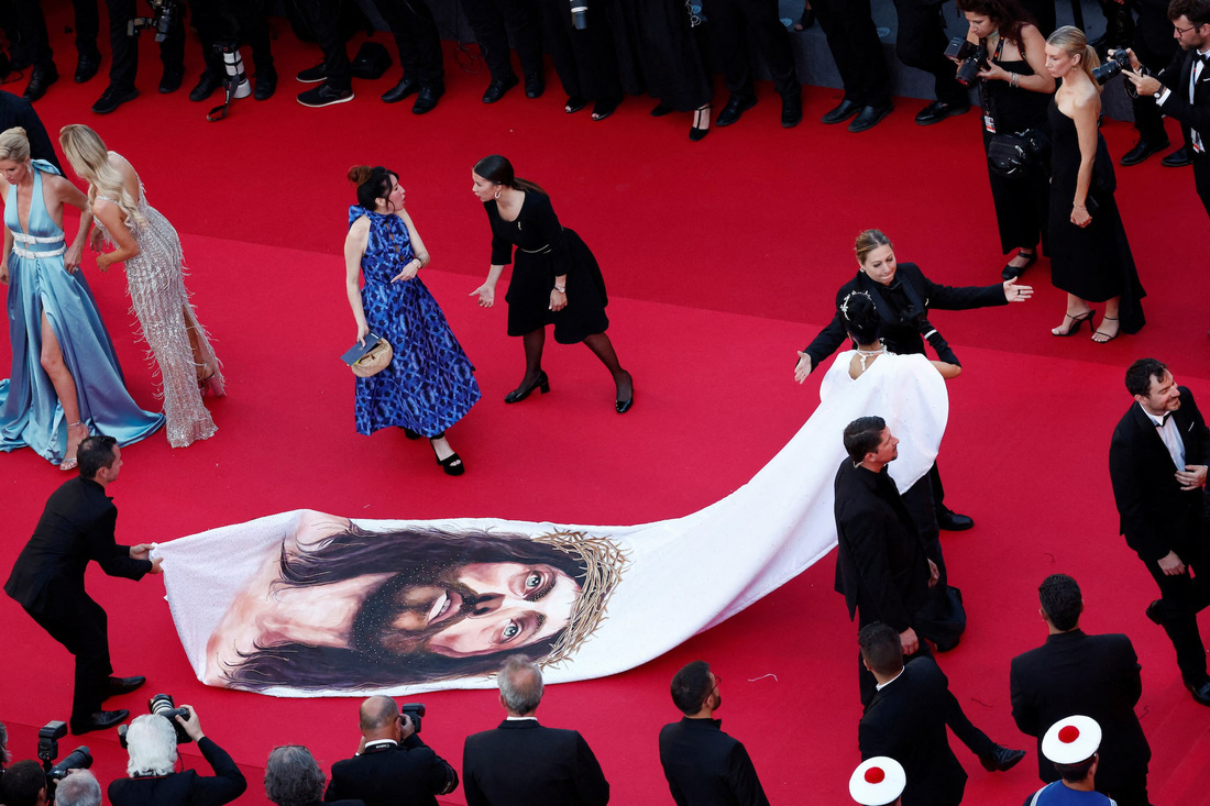 Một vị khách mặc váy độc lạ, in hình Chúa, bước đi trên thảm đỏ buổi chiếu phim Le Comte de Monte-Cristo - Ảnh: Reuters