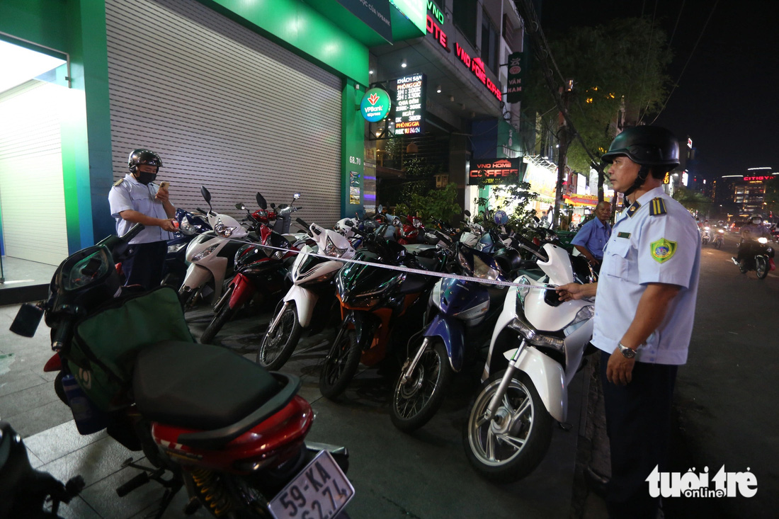 Lực lượng chức năng kiểm tra các chỗ đậu xe quá vạch theo quy định trên đường Nguyễn Gia Trí, quận Bình Thạnh, TP.HCM - Ảnh: PHƯƠNG QUYÊN