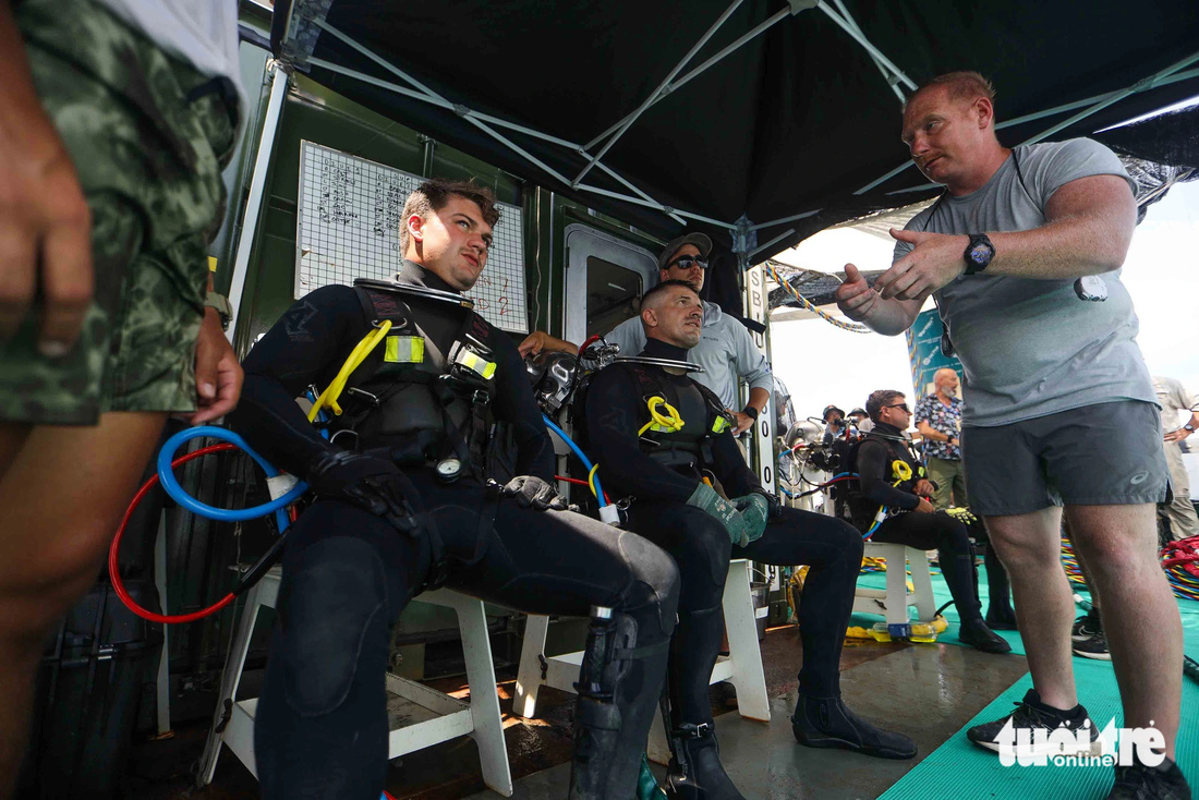 Chỉ huy lực lượng thợ lặn phổ biến một số yêu cầu nhiệm vụ trong ngày. Các thợ lặn tham gia chuyến tìm kiếm lần này thuộc bộ binh Mỹ- Ảnh: NGUYỄN KHÁNH