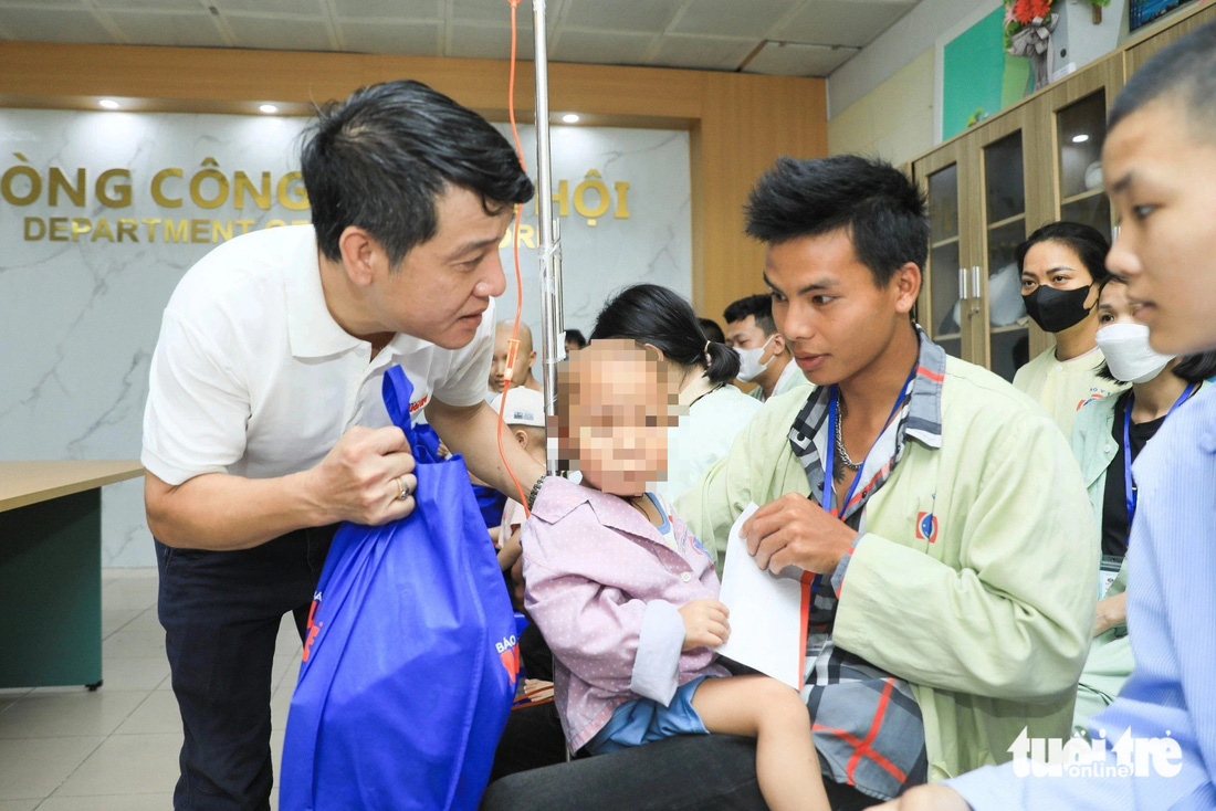 Đại diện báo Tuổi Trẻ trao tặng quà Ước mơ của Thúy cho bệnh nhi tại Bệnh viện K (cơ sở Tân Triều) - Ảnh: DANH KHANG