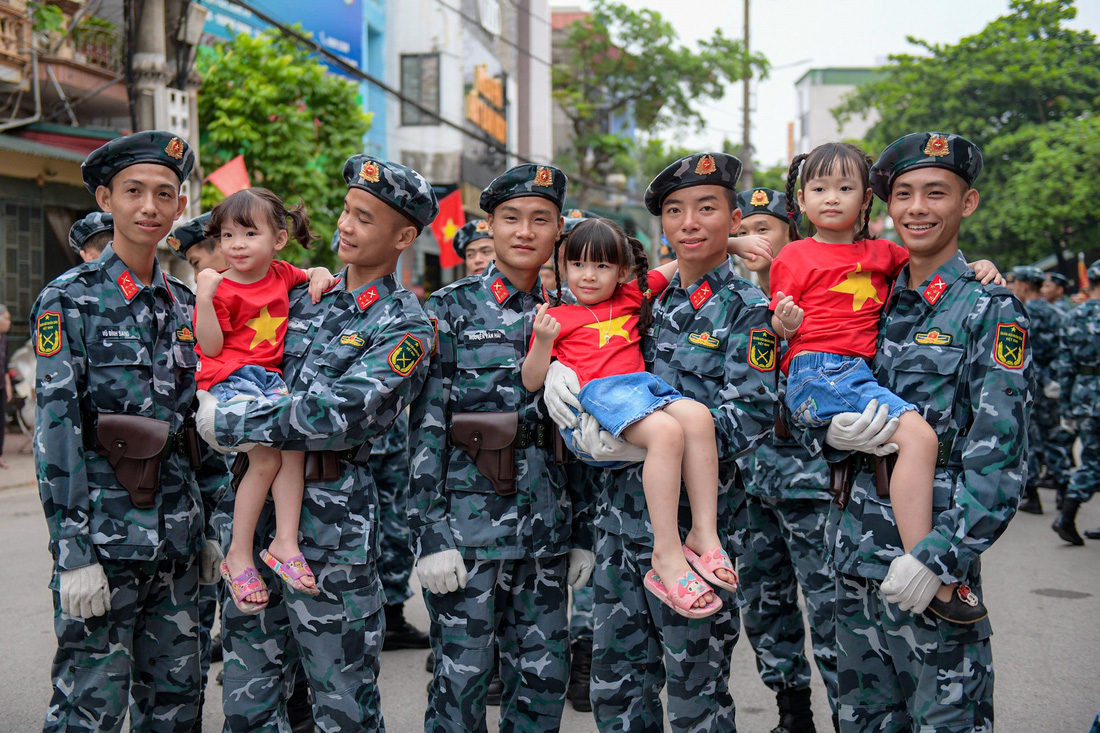 Các em nhỏ mặc áo cờ Tổ quốc chụp ảnh cùng các chiến sĩ trước giờ sơ duyệt - Ảnh: NAM TRẦN