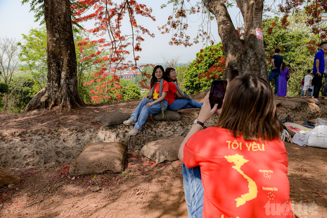 Các bạn trẻ với áo quốc kỳ, bản đồ Việt Nam chụp ảnh bên những tán cây phượng nở đỏ rực tại đồi A1