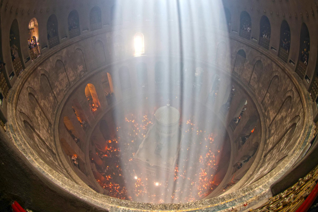 Nhà thờ Mộ Thánh, địa điểm được cho là nơi đặt thi hài Chúa Giêsu sau khi người chịu đóng đinh trên thập giá, đỏ rực bởi ngọn lửa Phục sinh đêm 4-5 - Ảnh: AFP