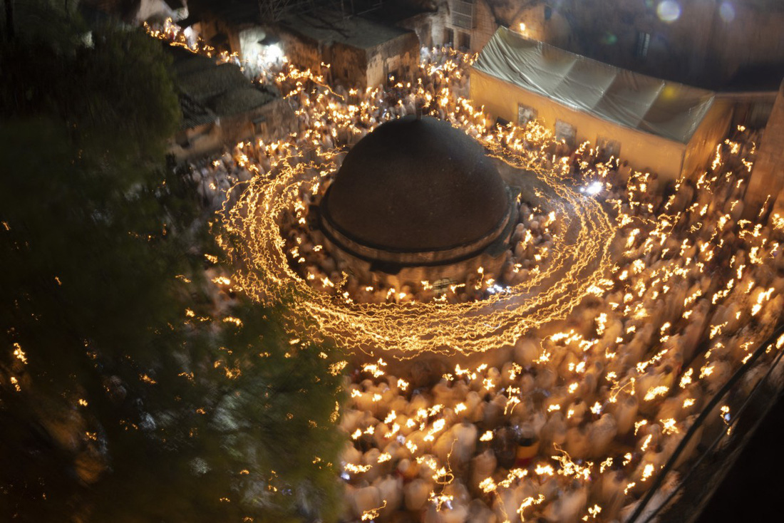 Những người hành hương cầm nến đi vòng quanh tu viện Deir Al-Sultan, trên nóc nhà thờ Mộ Thánh, thành cổ Jerusalem tối 4-5, tức đêm trước lễ Phục sinh theo lịch của Chính Thống giáo - Ảnh: AFP