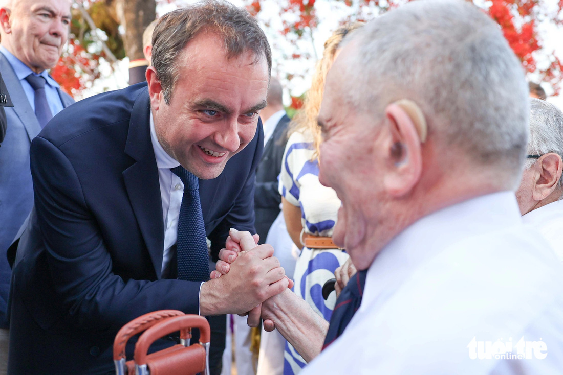 Bộ trưởng Sébastien Lecornu bắt tay một cựu chiến binh Pháp từng tham chiến tại Điện Biên Phủ - Ảnh: NGUYỄN KHÁNH