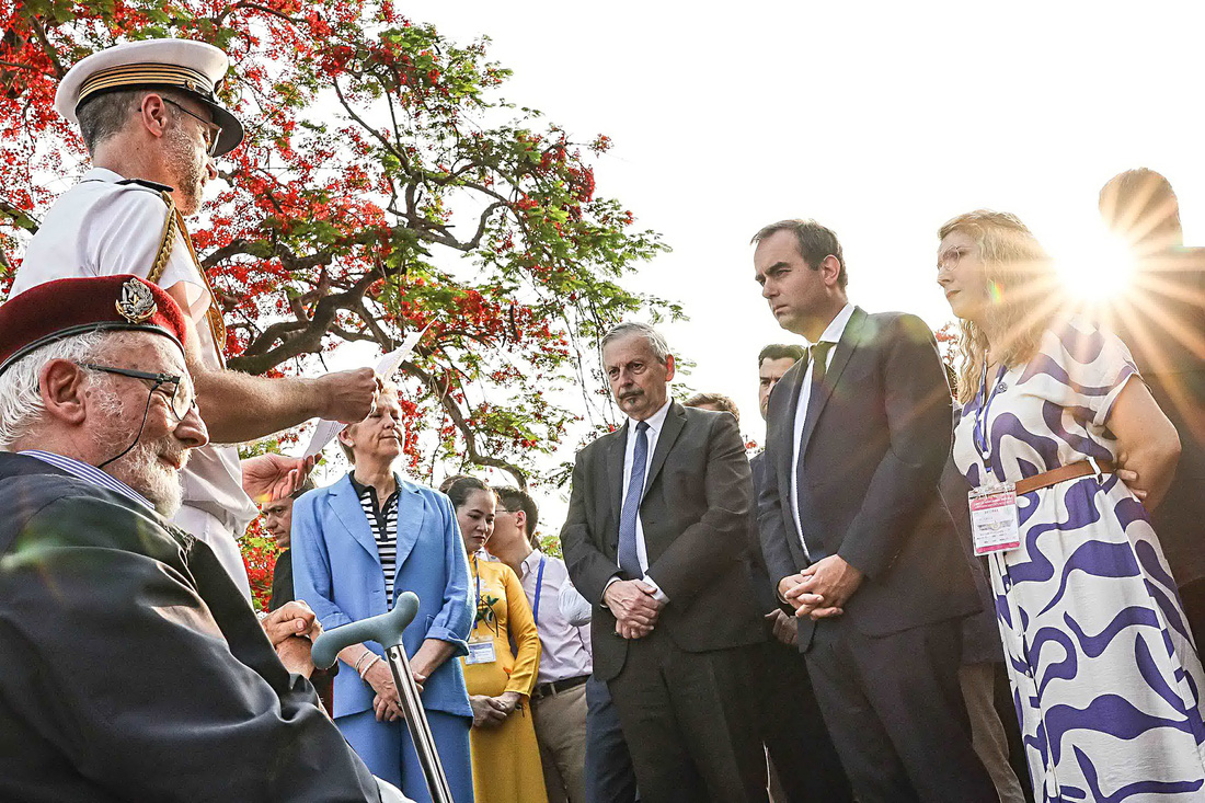 Bộ trưởng Quân đội Pháp Sébastien Lecornu và bà Quốc vụ khanh Patricia Miralles chăm chú nghe thư của một cựu chiến binh Pháp tham chiến tại Điện Biên Phủ (ảnh chụp tại đồi A1 vào chiều 6-5) - Ảnh: NGUYỄN KHÁNH