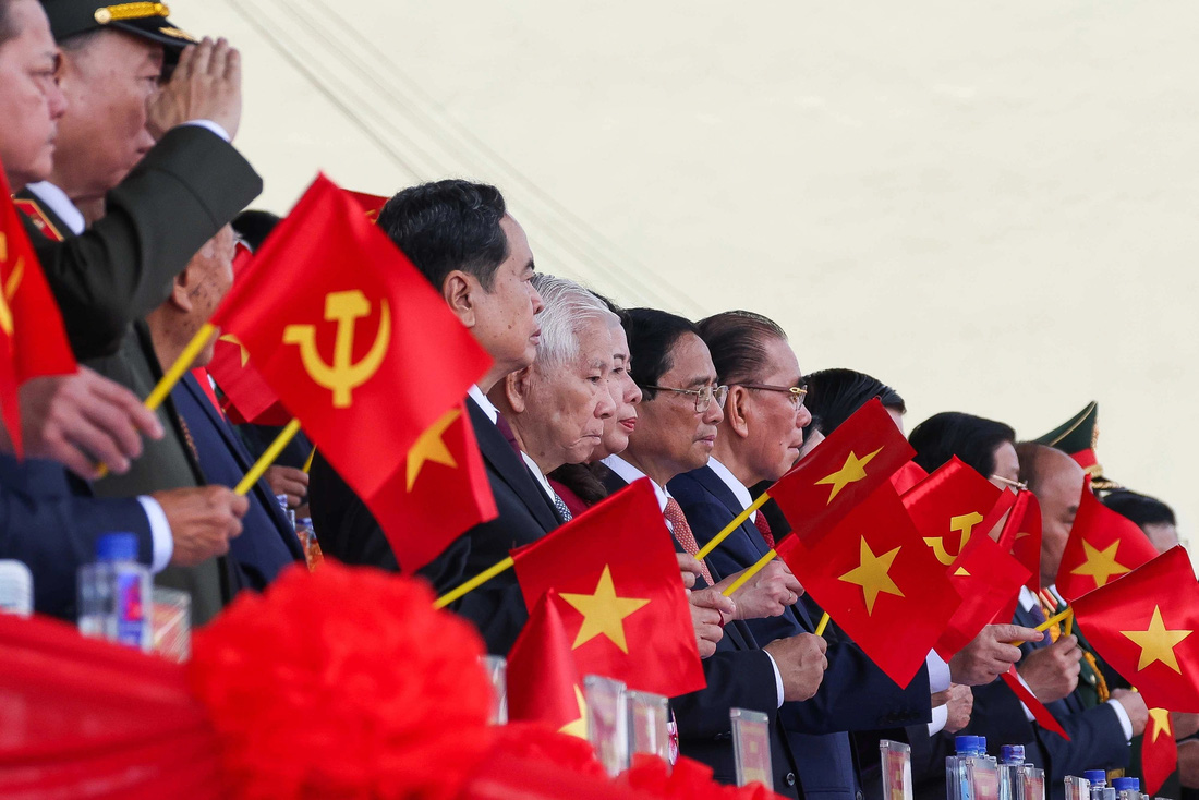 Các đồng chí lãnh đạo, nguyên lãnh đạo Đảng, Nhà nước vẫy cờ chào đón các khối lực lượng tiến vào lễ đài - Ảnh: NGUYỄN KHÁNH
