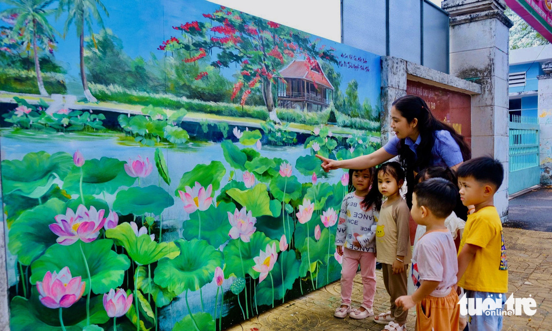 Cô giáo hướng dẫn các bé xem tranh bích họa sen Trường mầm non Hồng Gấm, TP Cao Lãnh - Ảnh: ĐẶNG TUYẾT