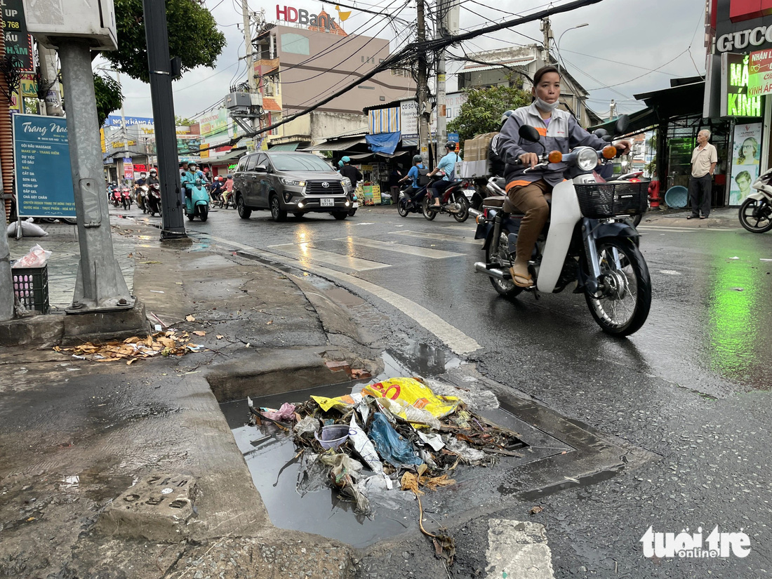 Từng mảng rác trôi chặn cứng miệng cống thoát nước - Ảnh: CHÂU TUẤN