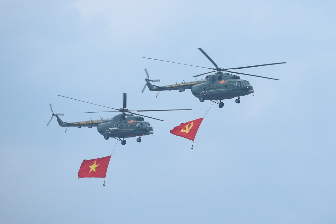 Các biên đội trực thăng vũ trang thuộc Quân chủng Phòng không - Không quân, Quân đội nhân dân Việt Nam mang theo cờ Đảng, cờ Tổ quốc Việt Nam diễu hành tiến qua sân vận động Điện Biên - Ảnh VGP