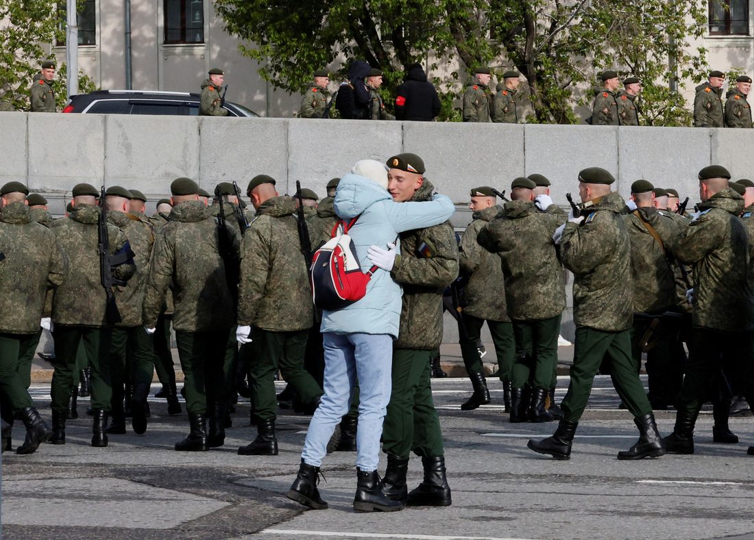 Một quân nhân và người thân trao nhau cái ôm trong lúc đợi duyệt binh tại quảng trường Đỏ, thủ đô Matxcơva vào sáng 9-5 - Ảnh: REUTERS