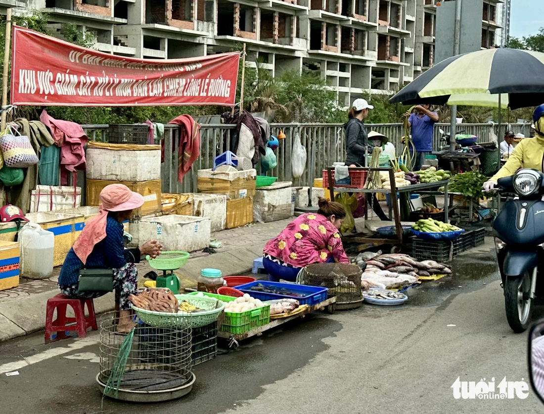 Nghiễm nhiên buôn bán ngay dưới băng rôn có ghi khu vực giám sát xử lý việc lấn chiếm lòng lề đường - Ảnh: KHẮC HIẾU