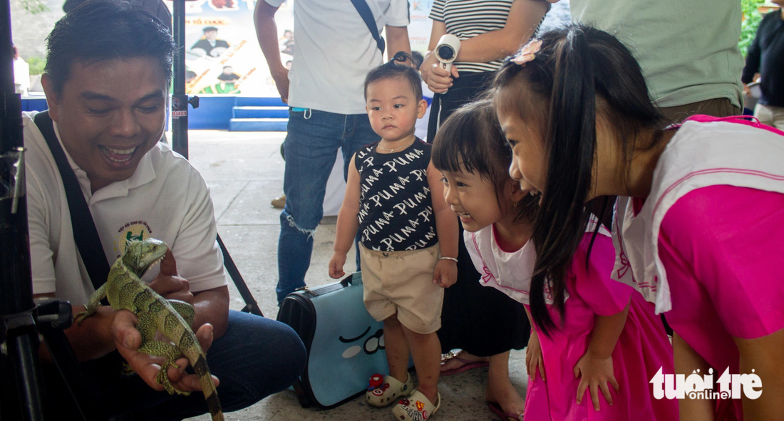 Các bạn nhỏ thích thú với chú kỳ nhông tại gian triển lãm của Lễ hội Cá cảnh Thú cưng TP.HCM - Ảnh: TÔ CƯỜNG