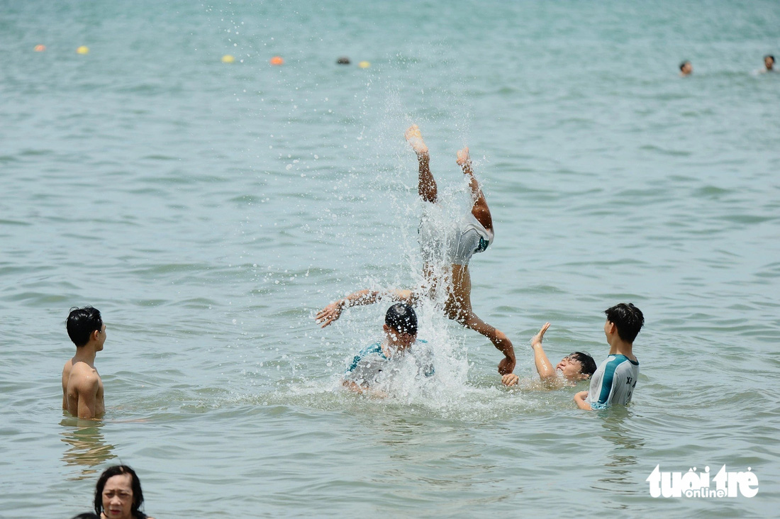 Người dân và du khách ở TP Quy Nhơn tắm biển dịp Tết Đoan ngọ - Ảnh: LÂM THIÊN