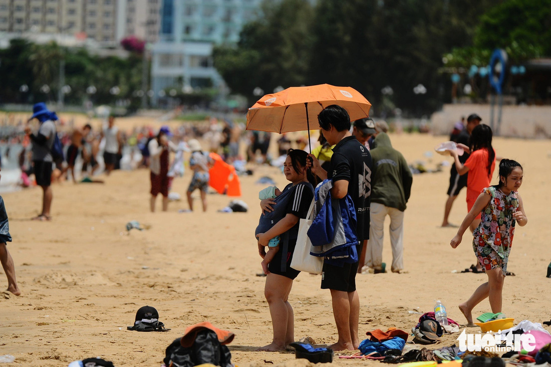 Nhiều du khách cùng con nhỏ vẫn ra bãi biển Quy Nhơn (Bình Định) giữa trưa để tắm cùng người dân địa phương, cầu may trong ngày Tết Đoan ngọ - Ảnh: LÂM THIÊN
