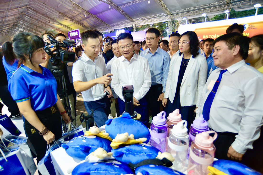 Phó thủ tướng Lê Thành Long và các đại biểu xem thanh toán bằng công nghệ xác thực sinh trắc học tại gian hàng NAPAS - Ảnh: QUANG ĐỊNH