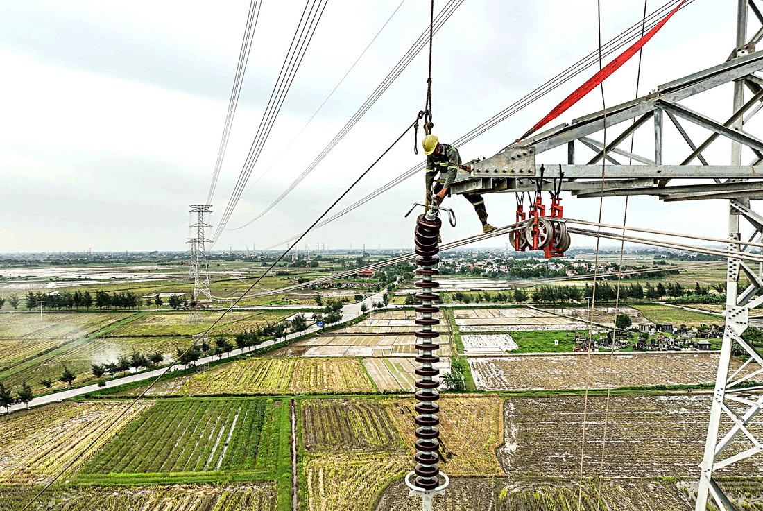 Công nhân kéo chuỗi sứ cách điện ở độ cao 60m tại huyện Hưng Hà (Thái Bình)