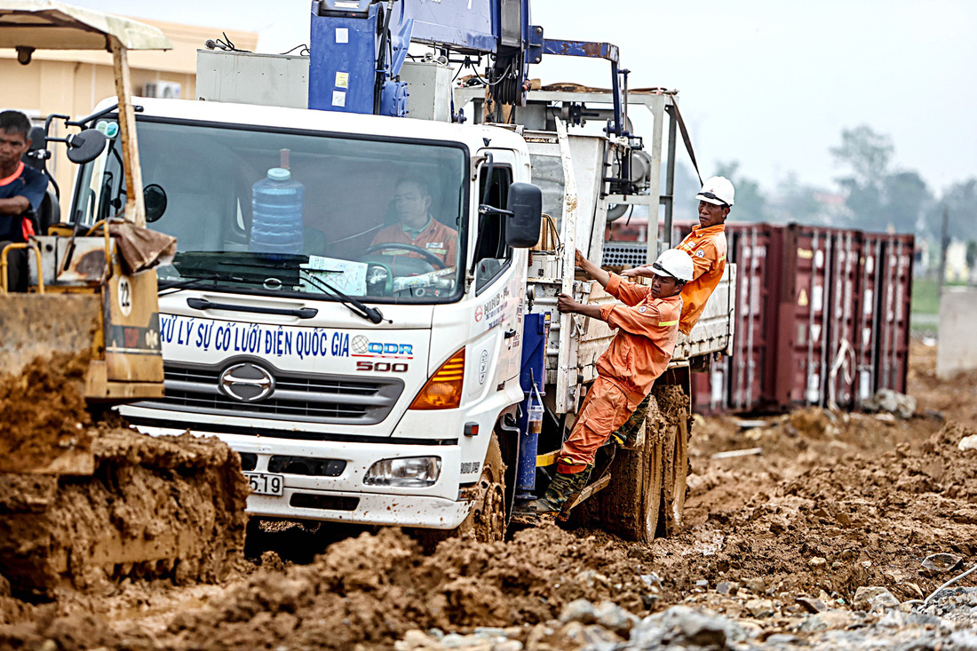 Đội thi công cố gắng đưa thiết bị qua một con đường lầy lội bùn đất sau cơn mưa lớn tại huyện Thiệu Hóa, Thanh Hóa