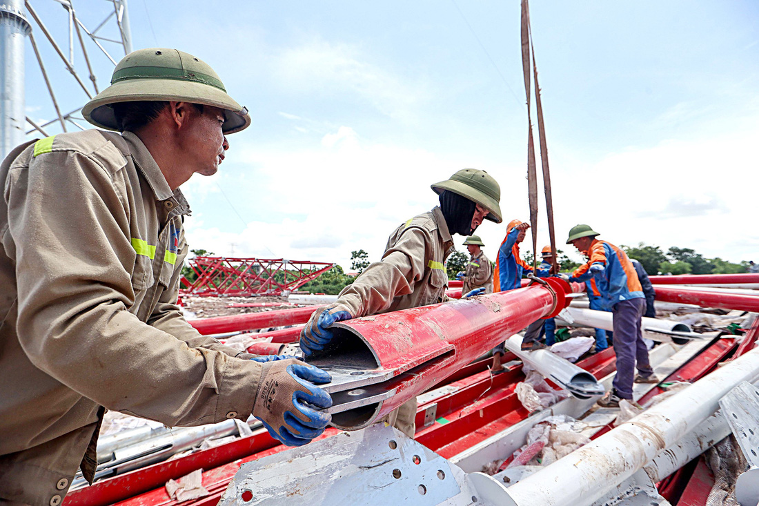 Giữa trưa nắng, công nhân vẫn miệt mài làm việc tại cột 120 kéo điện qua sông Hồng nối giữa hai tỉnh Nam Định và Thái Bình