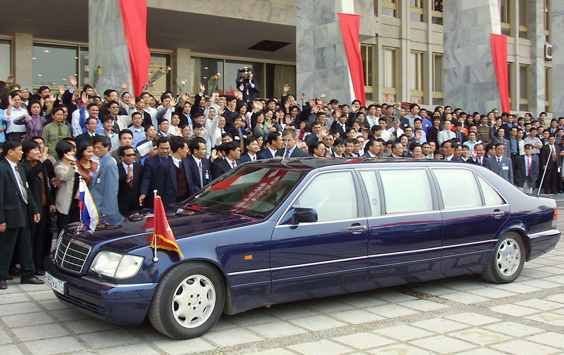 Người Việt Nam từng học ở Liên Xô chào xe chở ông Putin trước Cung Hữu nghị Việt - Xô ở Hà Nội, ngày 2-3-2001 - Ảnh: AFP