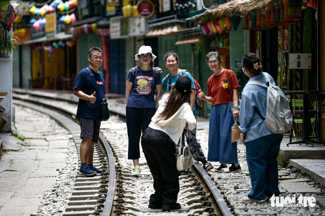 Nhiều du khách vẫn đến phố cà phê đường tàu đoạn qua phường Hàng Bông, quận Hoàn Kiếm check-in - Ảnh: NAM TRẦN