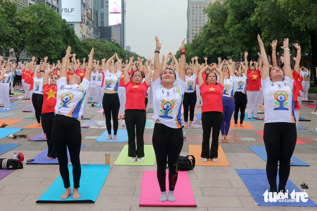 Hơn 1.000 người đến tham gia đồng diễn yoga tại phố đi bộ Nguyễn Huệ sáng 21-6 - Ảnh: HOÀNG TRANG