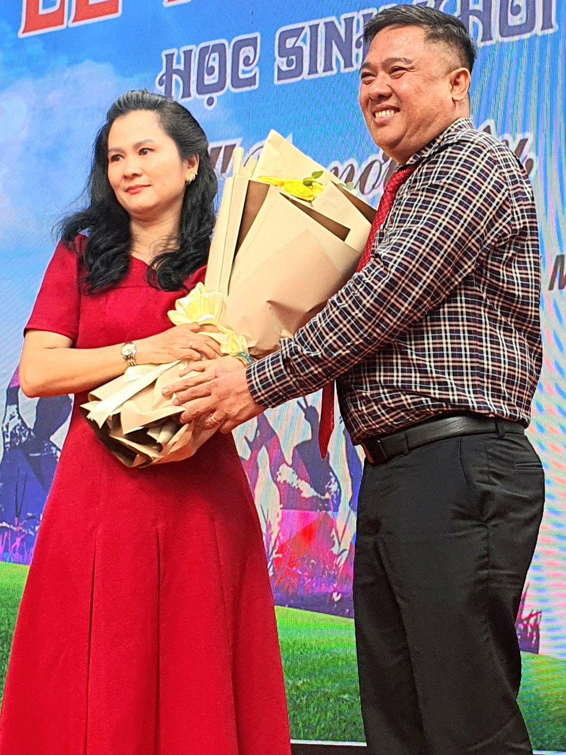 Ông Dương Văn Thư, hiệu trưởng Trường THPT Nguyễn Thị Diệu tặng hoa tri ân phụ huynh - Ảnh: HOÀNG HƯƠNG