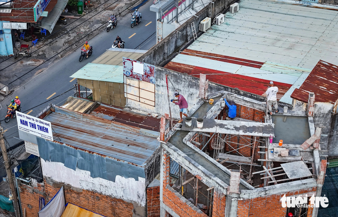 Nhiều nhà dân sinh sống trên đường Nguyễn Thị Định bắt đầu sửa sang nhà cửa, xây lùi nhà vào trong để bàn giao mặt bằng mở rộng đường - Ảnh: CHÂU TUẤN