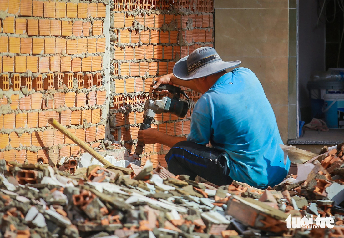 Một bức tường của căn nhà trên đường Nguyễn Thị Định đang được người dân khoan, tháo dỡ - Ảnh: CHÂU TUẤN