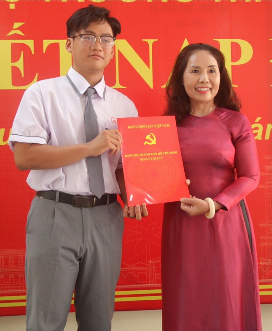 Bà Trương Thị Bích Thủy, hiệu trưởng Trường THPT Hùng Vương, trao quyết định kết nạp Đảng cho Hà Minh Nhật - Ảnh: KIM ANH