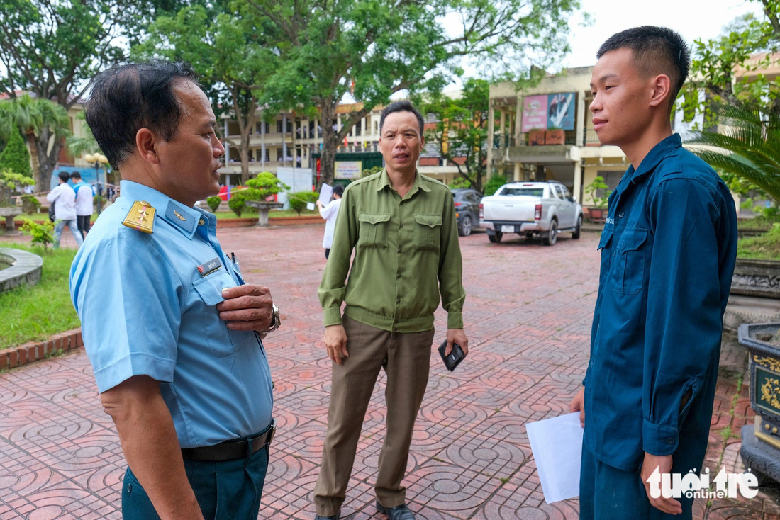 Cán bộ tại đơn vị chiến sĩ Nguyễn Quốc Triệu đóng quân (bìa trái) và cha Triệu nhắc nhở thí sinh về tác phong trước khi đi thi - Ảnh: HÀ QUÂN