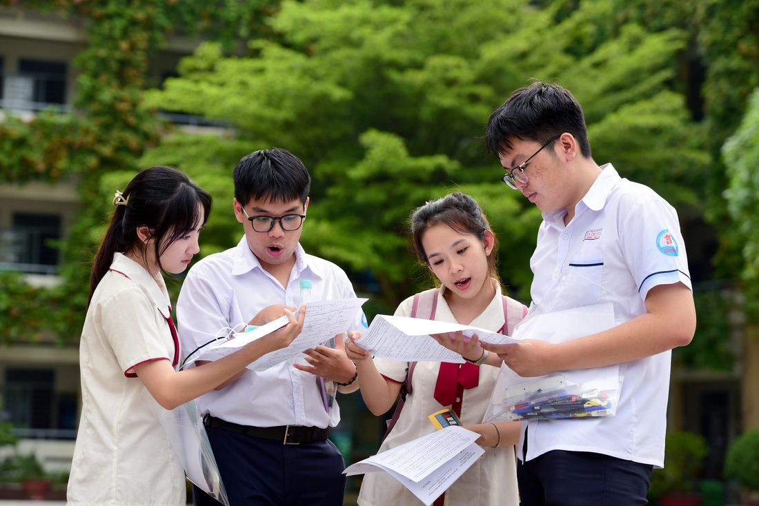 Khải Tường (bìa phải) cùng nhóm bạn kiểm tra lại kết quả sau khi thi môn toán tại điểm thi THPT Phú Nhuận, TP.HCM - Ảnh: DUYÊN PHAN