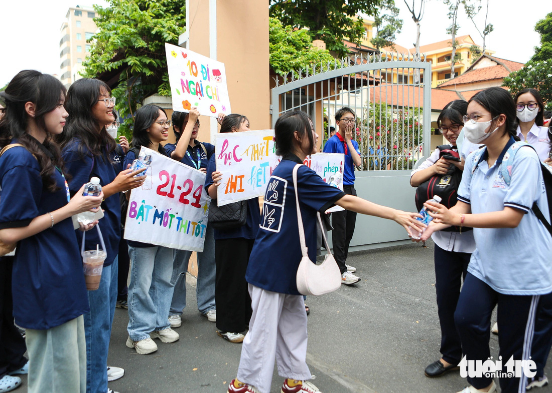 Tại cổng Trường THPT Lê Hồng Phong, TP.HCM, những tấm biển cổ vũ với khẩu hiệu như: "Học hết mình, thi nhiệt tình", "Tôi cho phép em điểm 10, 10 đi ngại chi"... được đội tình nguyện dùng chào đón các bạn trẻ bước ra từ phòng thi - Ảnh: PHƯƠNG QUYÊN