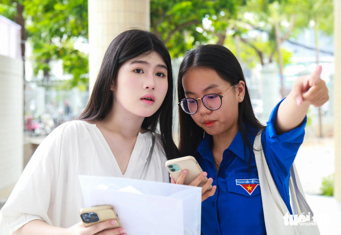 Tình nguyện viên Bảo Tiên (phải) hướng dẫn cho thí sinh Đà Nẵng - Ảnh: ĐOÀN NHẠN