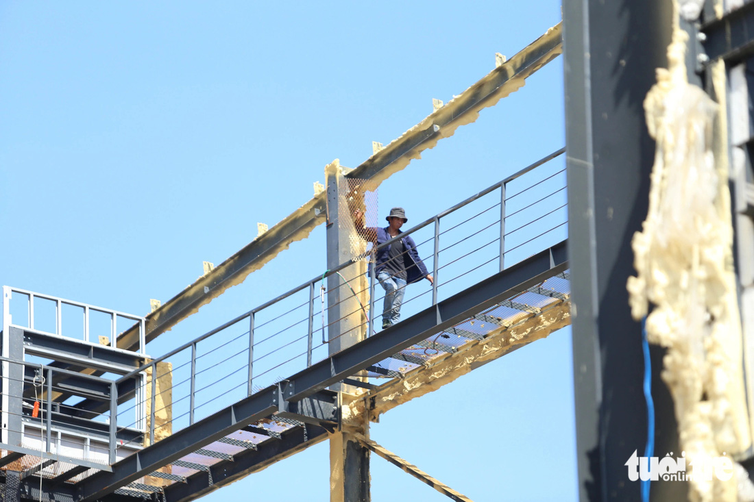 Một công nhân đang tháo tấm lưới sắt lắp trên cầu thang của công trình sai phép - Ảnh: ÁI NHÂN